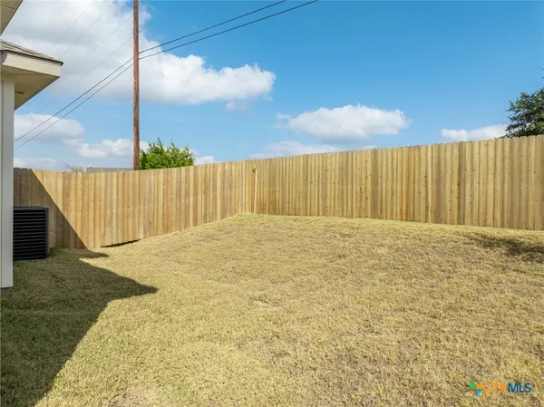 a view of backyard with wooden fence