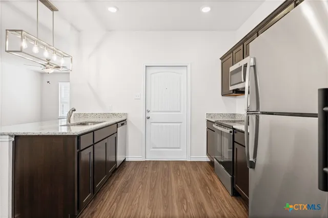 a kitchen with stainless steel appliances granite countertop a sink stove and refrigerator
