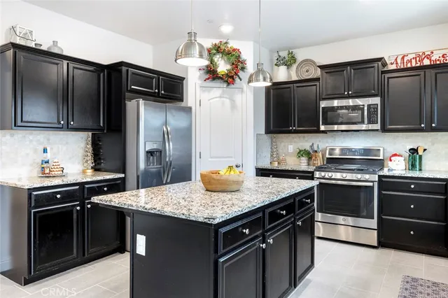 a kitchen with granite countertop stainless steel appliances and wooden cabinets