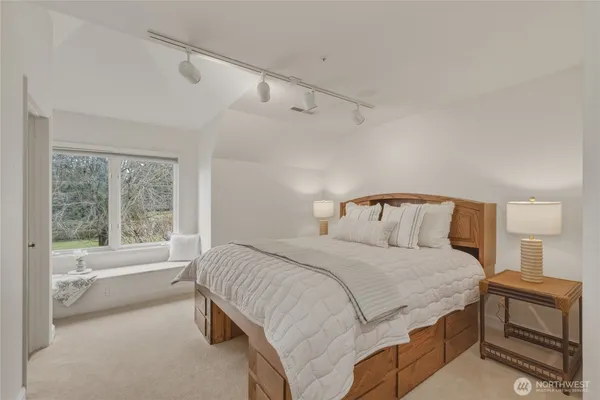 a bedroom with a bed and a large window