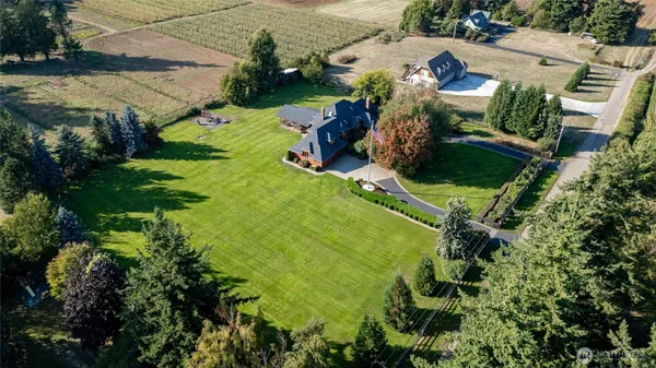 an aerial view of residential houses with outdoor space and trees all around