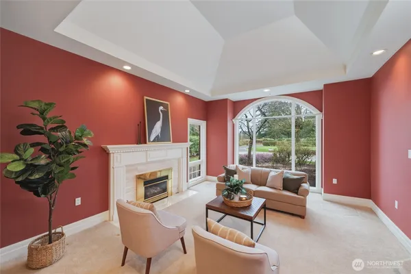 a living room with furniture a fireplace and a potted plant