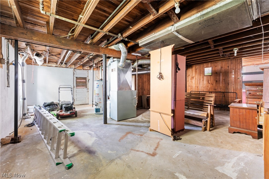 16 South State Street Rittman, OH 44270 - Photo 19 of 27 Unfinished below grade area featuring heating unit, wood walls, and water heater