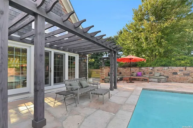 a view of a patio with a table and chairs under an umbrella