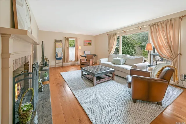 a living room with furniture fireplace and a large window