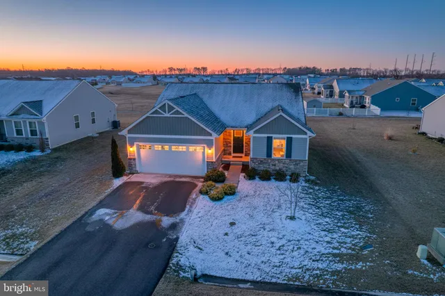 a view of a house next to a big yard with large tree