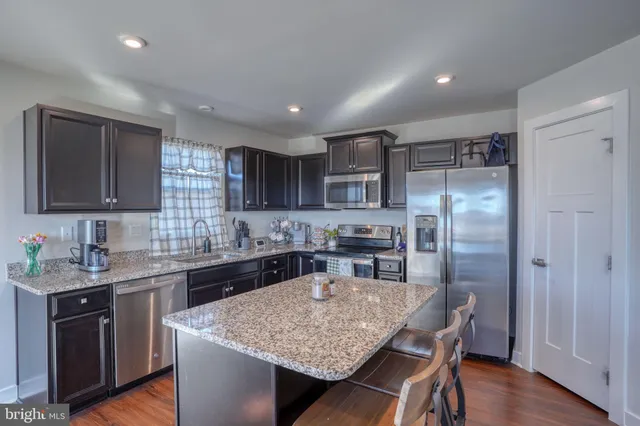 a kitchen with stainless steel appliances granite countertop a sink stove and microwave