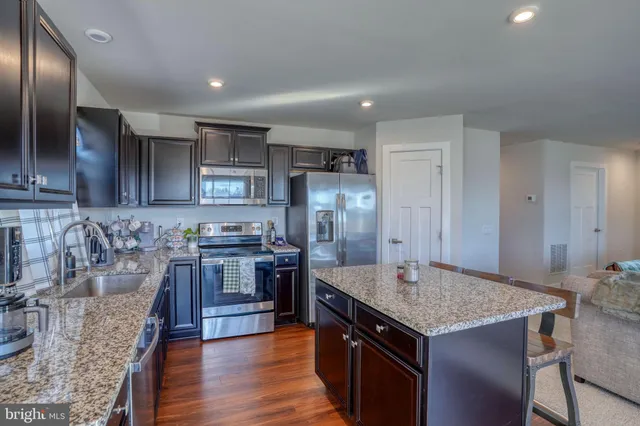 a kitchen with a stove a sink a dining table and chairs