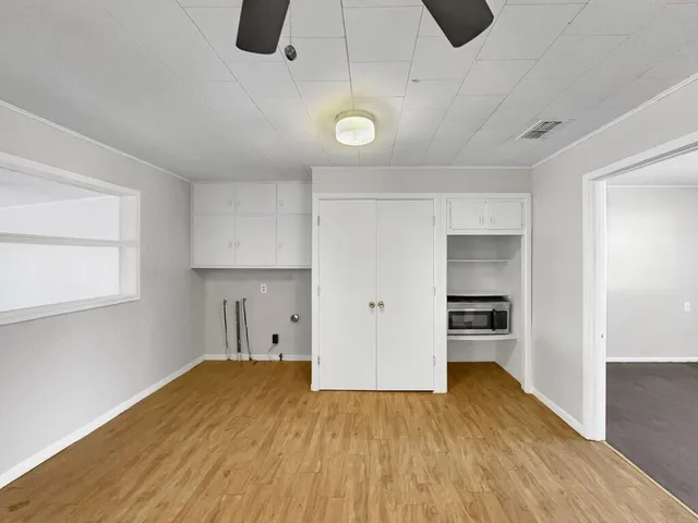 a view of empty room with wooden floor