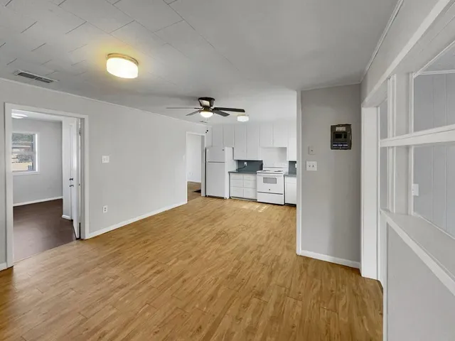 a view of empty room with wooden floor
