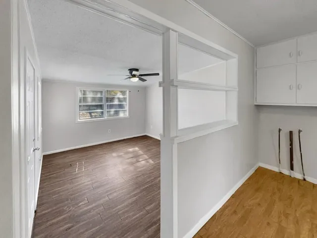 an empty room with wooden floor and windows