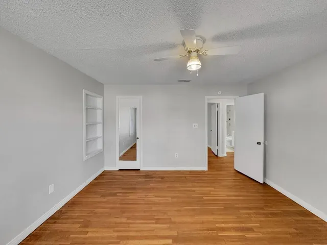 a view of empty room with wooden floor