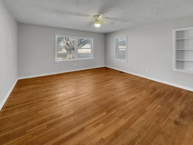 wooden floor in an empty room with a window