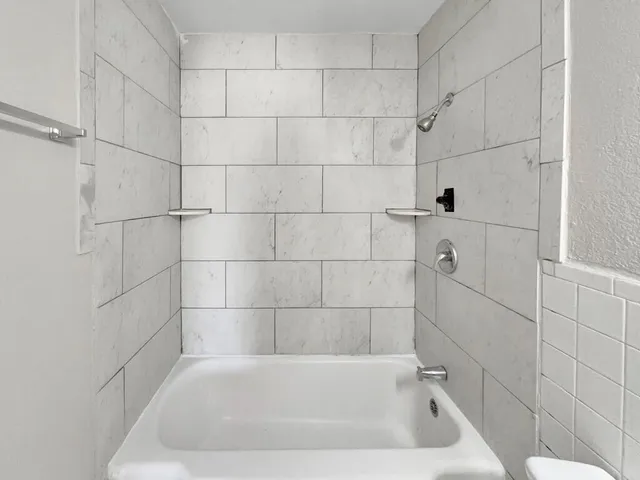 a bath tub sitting next to a white sink and vanity