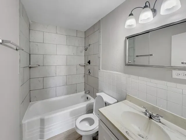a bathroom with a sink a toilet and bathtub