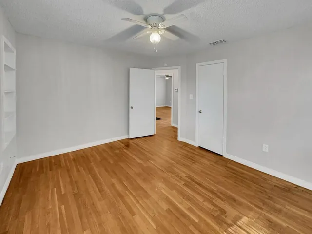 a view of empty room with wooden floor