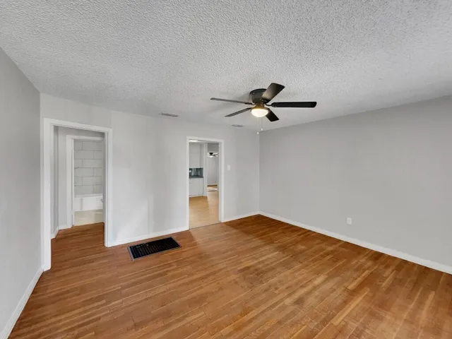 a view of empty room with wooden floor