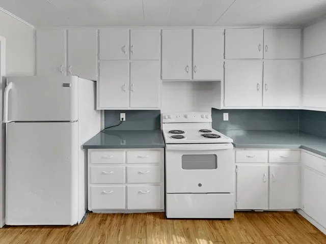 a kitchen with white cabinets and white appliances
