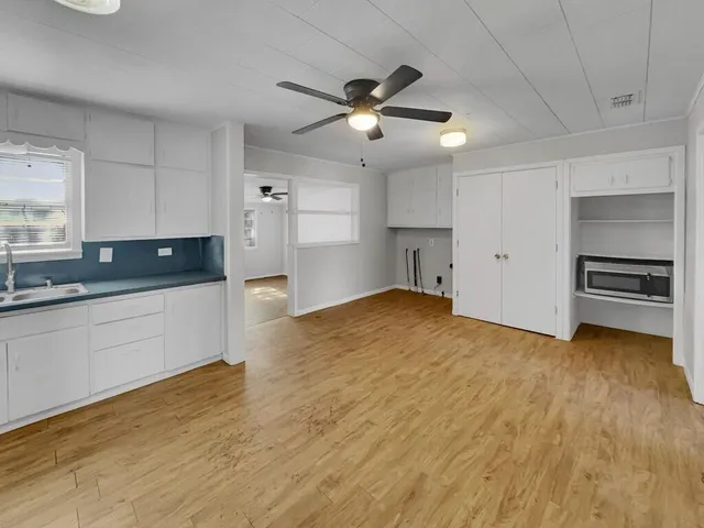 a view of empty room with wooden floor and window