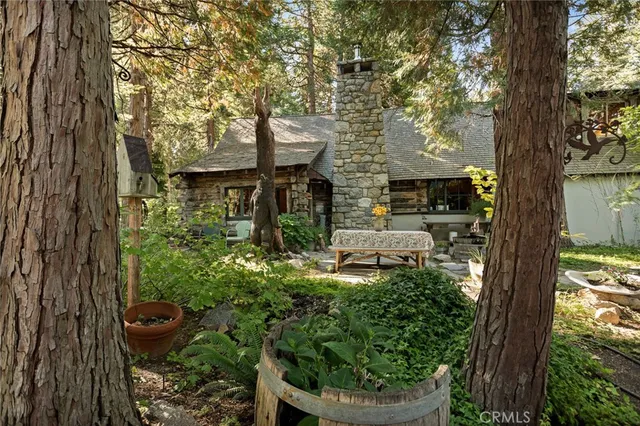 a view of a house with a small yard and a large tree