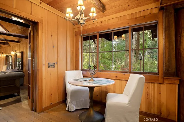 a dining room with furniture a chandelier and wooden floor