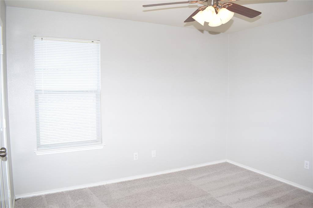 375 Housefinch Loop Leander, TX 78641 - Photo 17 of 28 A window with classic trim invites natural light onto the neat carpeted flooring.