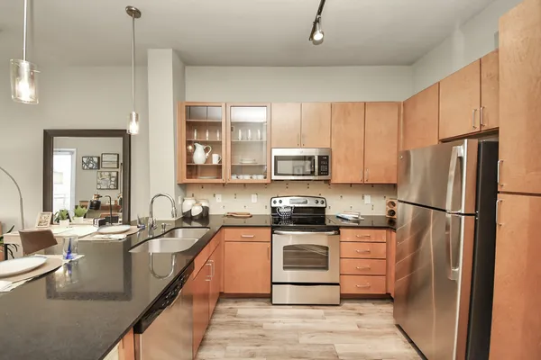 a kitchen with stainless steel appliances granite countertop a sink and a wooden cabinets