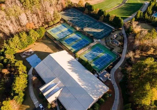 a view of a large building with a big yard and large trees