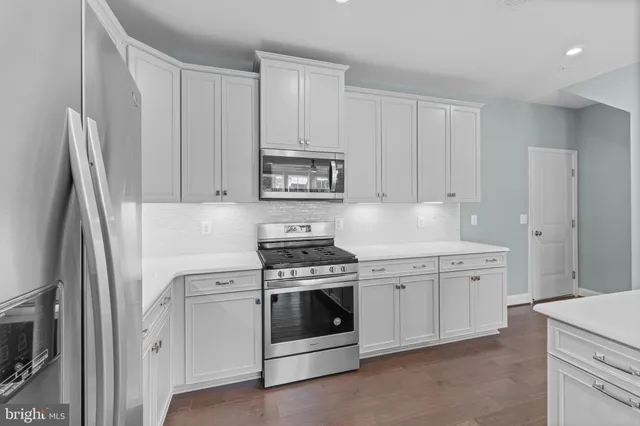 a kitchen with white cabinets and white appliances
