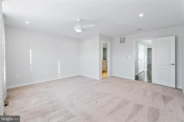 an empty room with fan and entrance