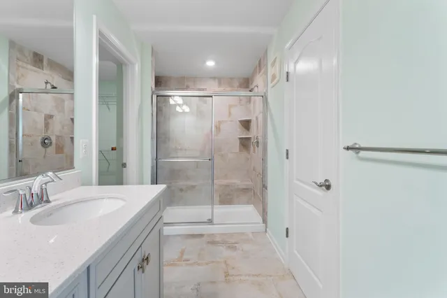a bathroom with a shower sink and mirror