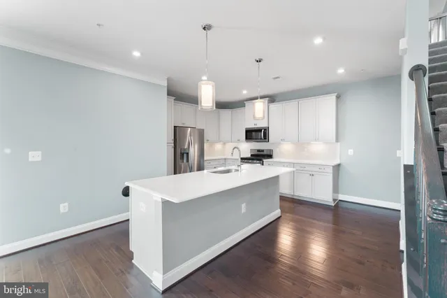 a kitchen with stainless steel appliances a sink stove refrigerator and cabinets