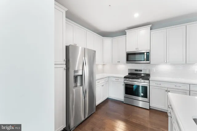 a kitchen with stainless steel appliances granite countertop a refrigerator stove and sink