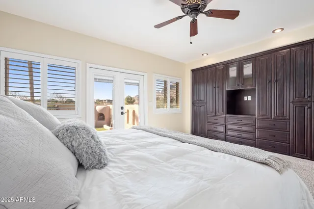 a bedroom with a bed and a chandelier fan