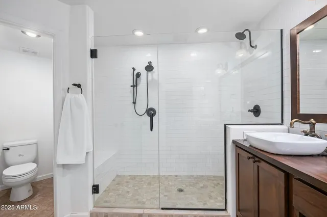 a bathroom with a granite countertop sink a mirror and shower