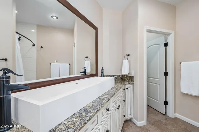 a bathroom with a granite countertop sink a toilet and shower