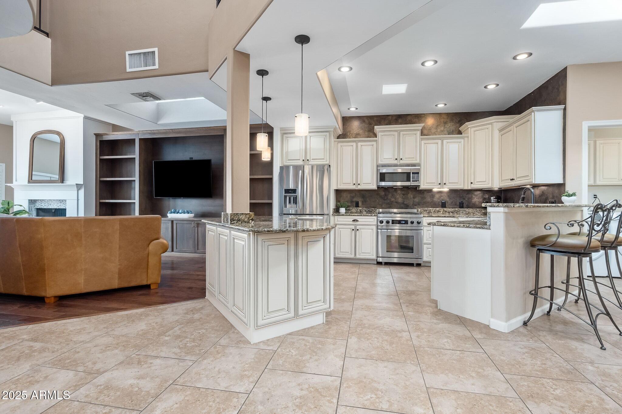 6547 North Turnberry Drive Tucson, AZ 85718 - Photo 4 of 51 a kitchen with kitchen island cabinets and refrigerator