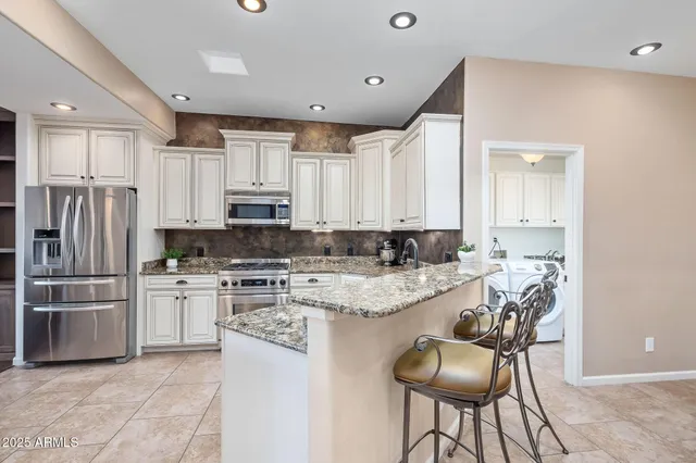 a large kitchen with granite countertop a sink and cabinets