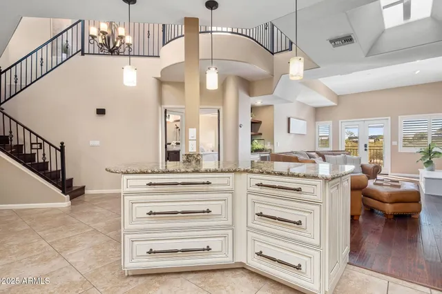 a kitchen with stainless steel appliances granite countertop a stove top oven a refrigerator a sink and white cabinets