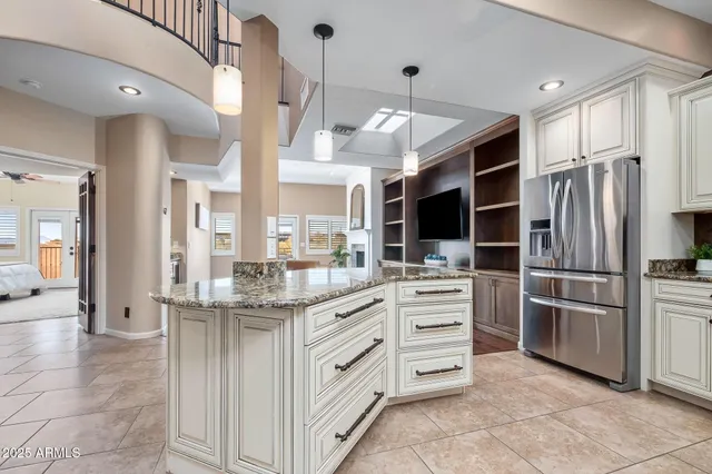 a kitchen with stainless steel appliances cabinets and a chandelier