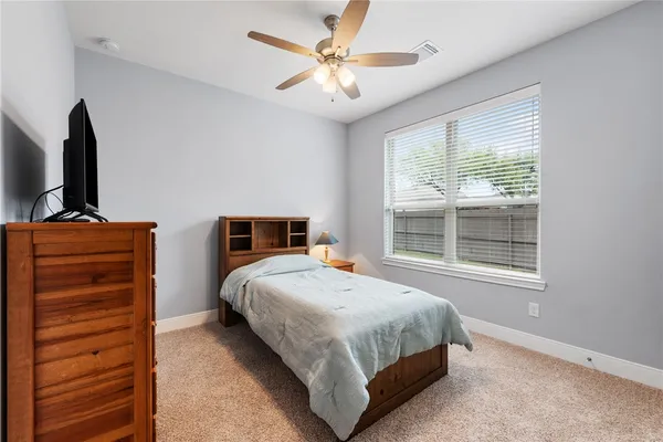 a bedroom with a large bed and a flat tv screen