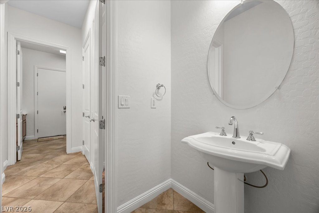 2125 De Rouge Avenue Henderson, NV 89044 - Photo 64 of 96 A pristine powder room offers a sleek pedestal sink and contemporary round mirror.