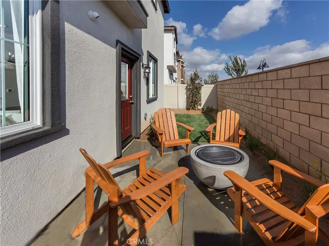 a view of a patio with table and chairs with wooden floor and fence