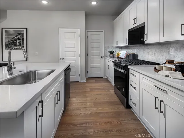 a kitchen with white cabinets sink and stainless steel appliances