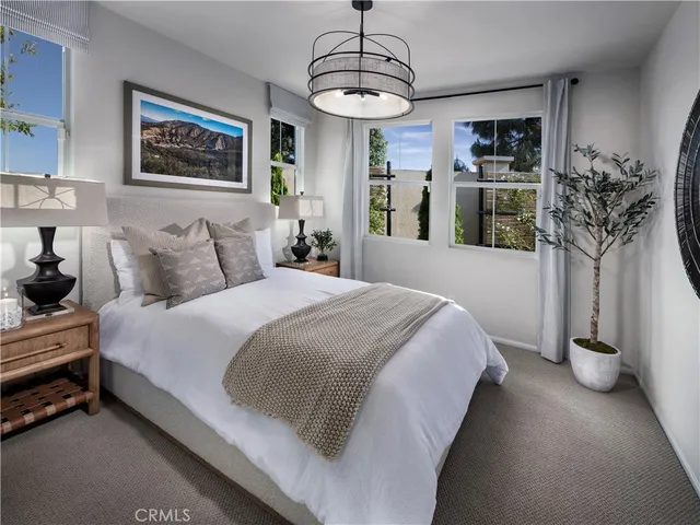 a spacious bedroom with a bed and a chandelier