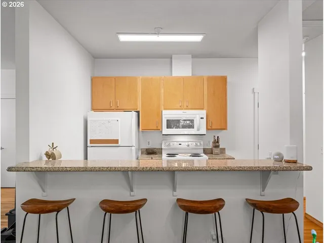 a kitchen with stainless steel appliances a table and chairs in it