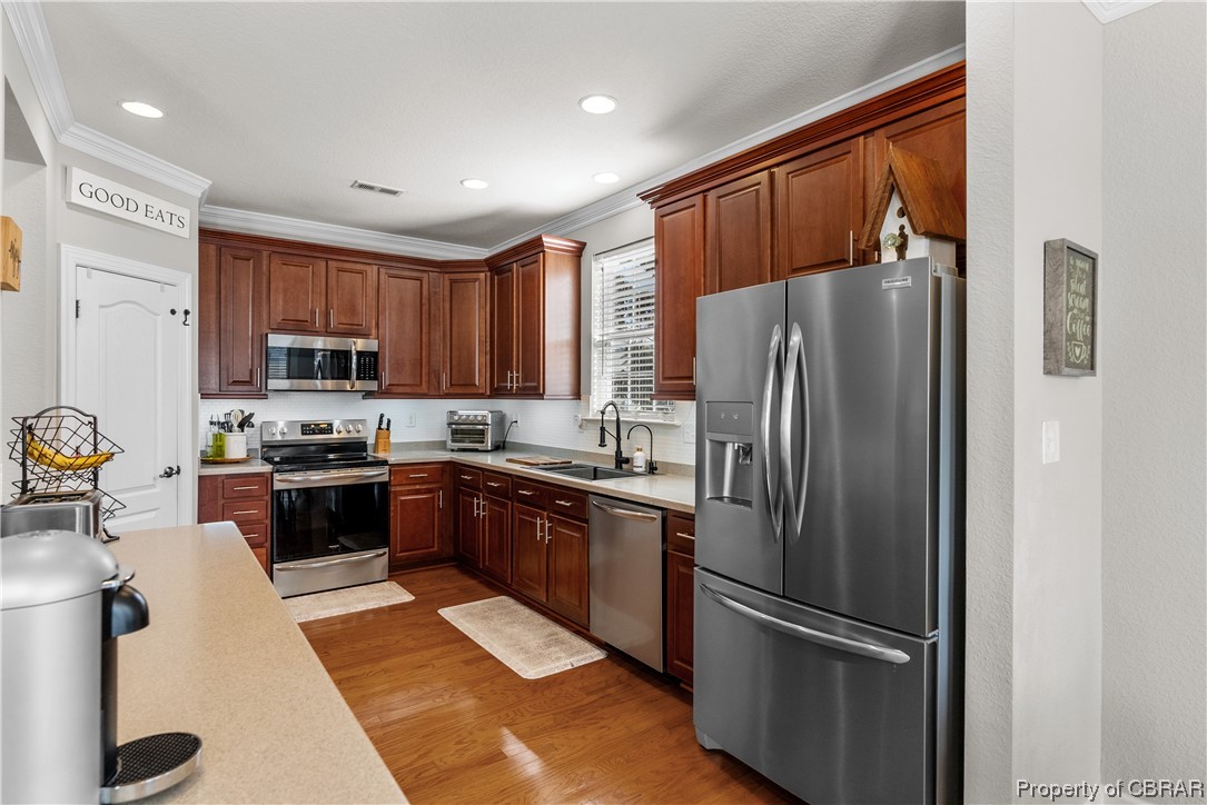 2124 Piedmont Road Suffolk, VA 23435 - Photo 23 of 41 Kitchen with sink, ornamental molding, stainless steel appliances, and light hardwood / wood-style floors