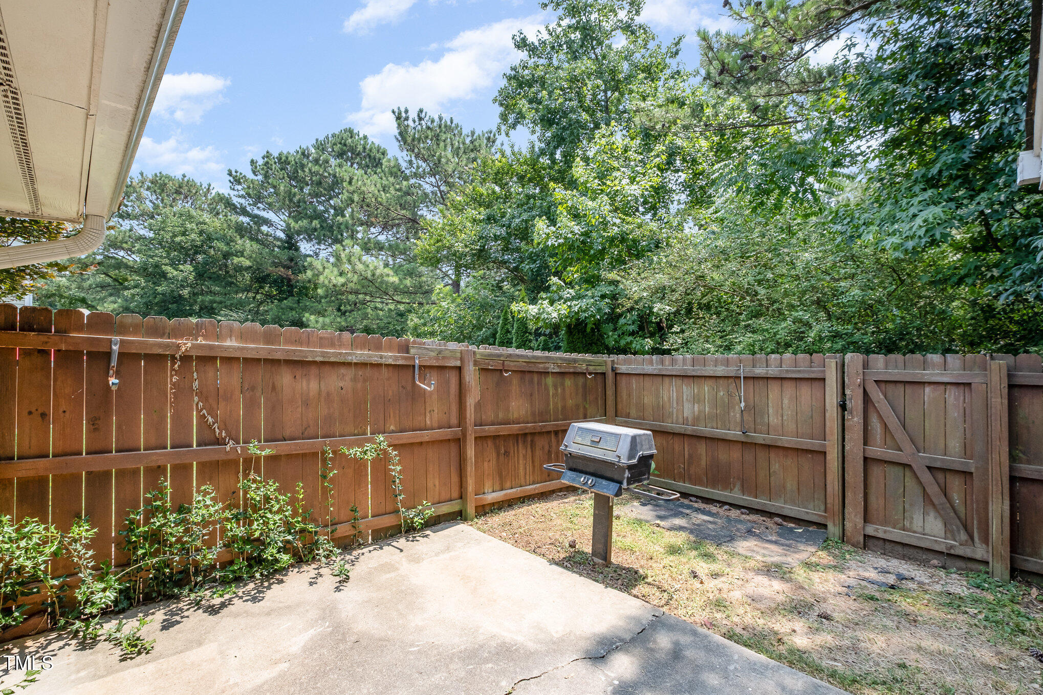 2213 Alpine Road Durham, NC 27707 - Photo 13 of 18 a backyard of a house with potted plants and covered with wooden fence