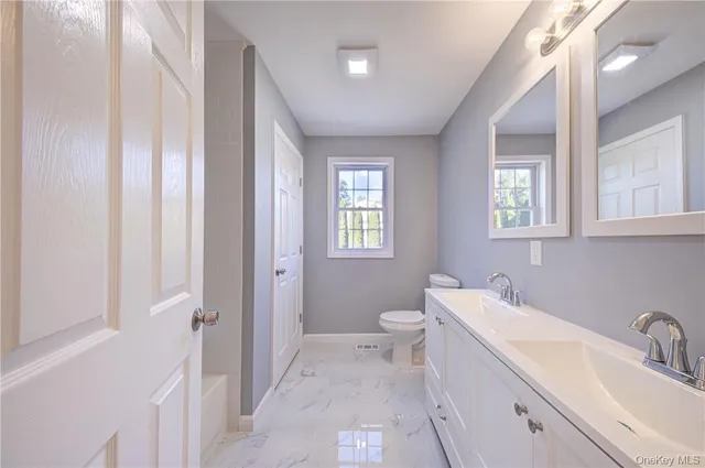 a bathroom with a toilet a sink and shower