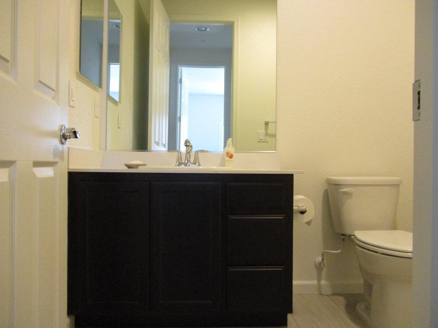 1027 Ruby Way Gilroy, CA 95020 - Photo 19 of 25 a bathroom with a sink a toilet and a mirror